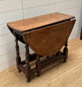 An oak gate leg table on turned supports (H54cm W100cm D77cm)