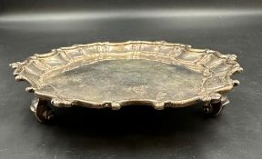 A Dublin hallmarked silver three scroll footed, scalloped edged stand. Weight 200g H3cm Dia15.5cm