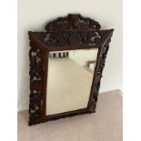 An ormate Oriental hardwood mirror with foliate frame (80cm H x 65cm W