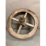 A vintage wooden four spoke wheel barrow wheel with metal rim