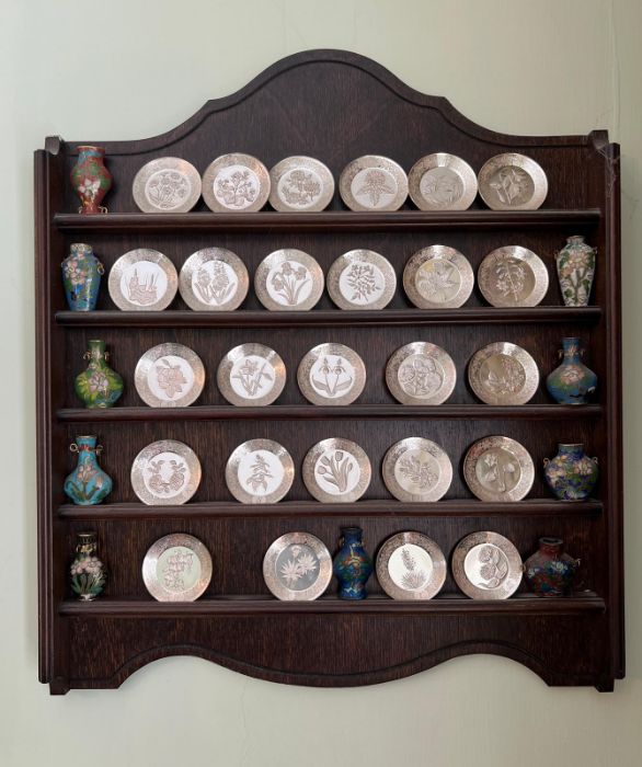 A collection of miniature plates along with enamel perfume bottles