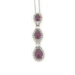 18 carat white gold pendant with 3 clusters of cabochon ruby and diamond. The clusters are separated