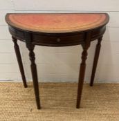 A Demi Lune mahogany side table with red leather top (H72cm W76cm D38cm)