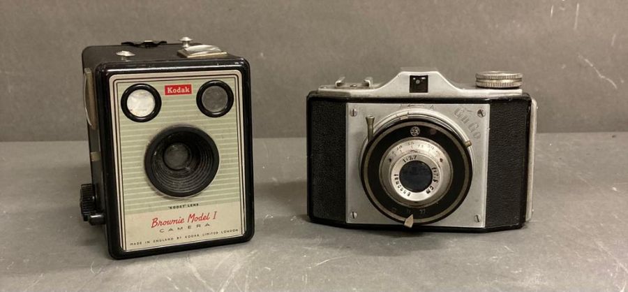 Two vintage cameras. A Kodak brownie model 1 and a Gu Go