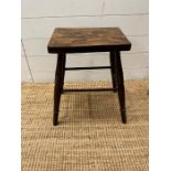 A stained pine footstool on turned legs.