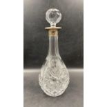 A cut glass decanter with silver hallmarked collar