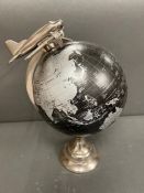 A globe with chrome moble plane