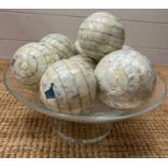 A glass bowl of mosaic style balls