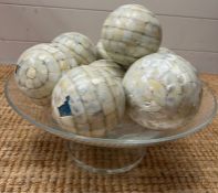 A glass bowl of mosaic style balls