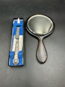 A silver handled knife along with an ebony handheld mirror with engraved silver strip to back.