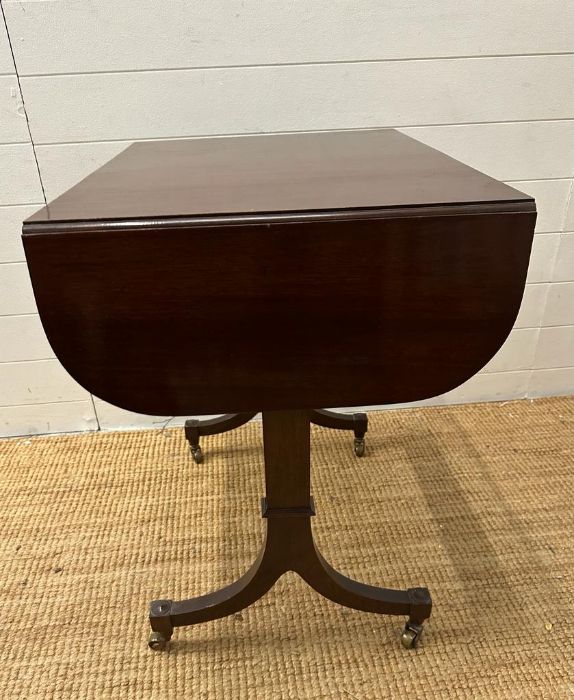 A mahogany drop leaf occasional table on splayed legs and castors (H73cm W108cm D51cm) - Image 2 of 4