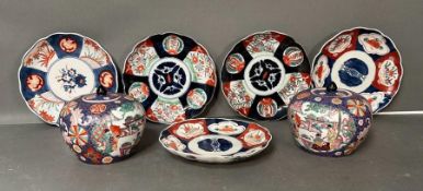 A pair of Chinese lidded vases and some Imari pattern plates.