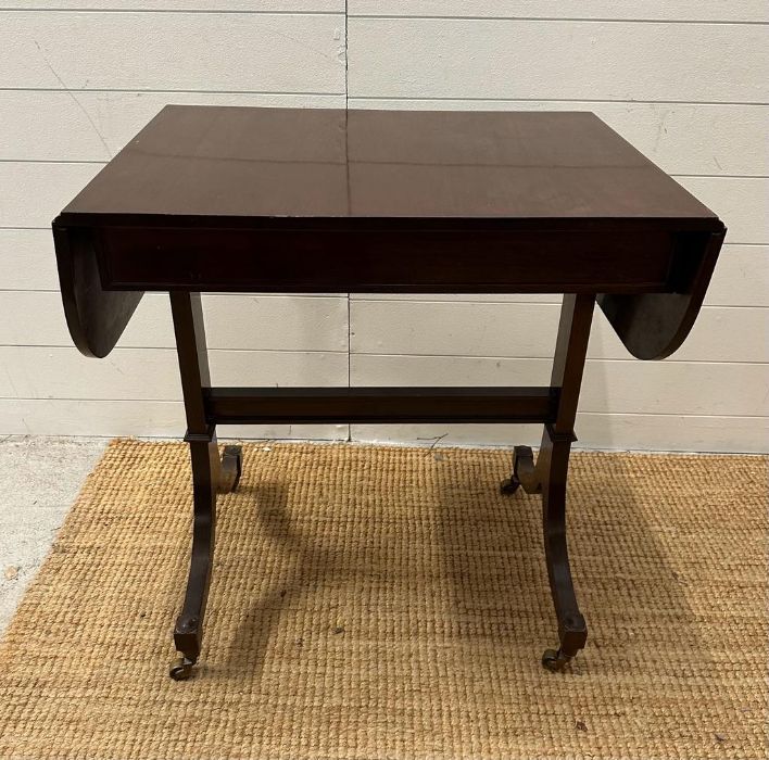 A mahogany drop leaf occasional table on splayed legs and castors (H73cm W108cm D51cm) - Image 3 of 4