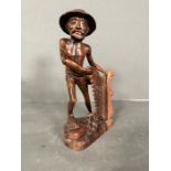 A carved figure of a fisherman holding his net. (Approximate Height 27cm)