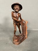 A carved figure of a fisherman holding his net. (Approximate Height 27cm)