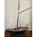 A model of a racing yacht on blue stand (H84cm W65cm)