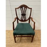 A mahogany shield back open armchair upholstered in green