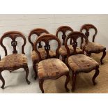 A set of six Victorian style spoon back chairs on cabriole legs with carved fleur details to backs