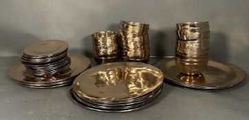 A hammered metal dinner service comprising of four serving plates, fourteen dinner plates, twenty