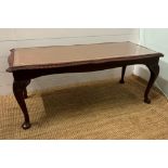 A mahogany and leather, glass topped coffee table