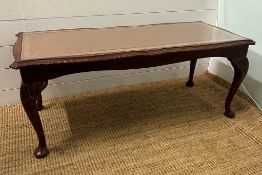 A mahogany and leather, glass topped coffee table