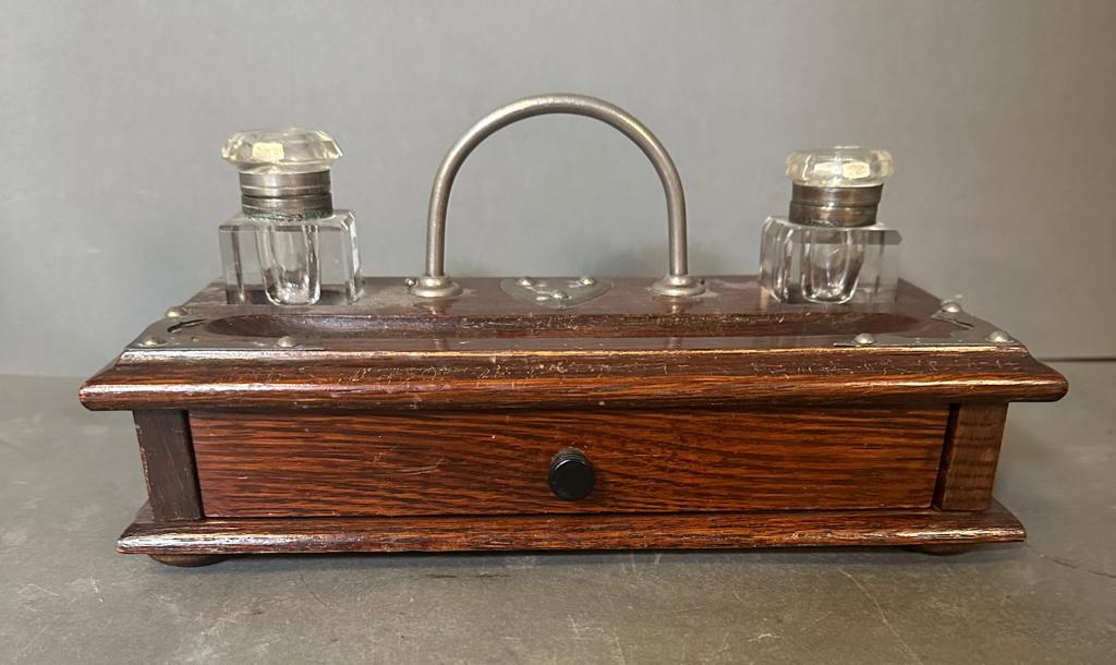 An oak ink stand or desk tidy with two ink wells and drawers under