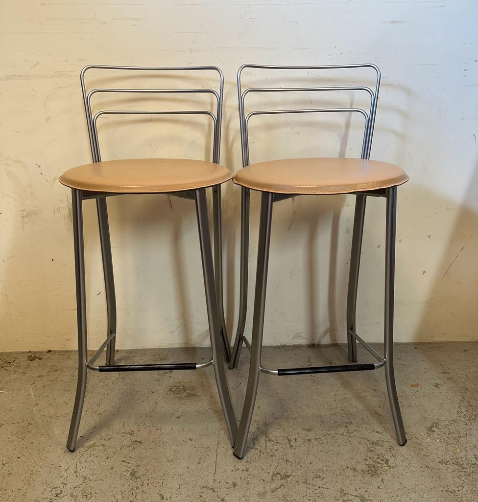 A pair of contemporary chrome bar stools, upholstered in faux beige leather (H94cm)