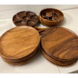A wooden dinner set comprising of sixteen wooden plates, one serving bowl, four sauce pots and