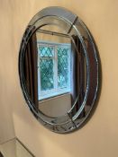 A circular mirror with mirrored panels to edge