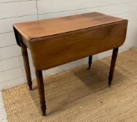A mahogany single drawer Pembroke table on turned legs and castors