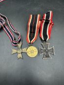Three German WWII medals to include A Merit Medal, War Merit Cross and an Iron Cross