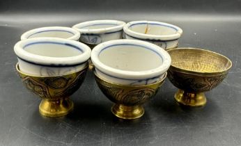 Six Chinese brass egg cups with blue and white ceramic liners AF
