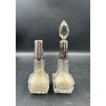 Two Art Deco cut glass perfume bottles with silver hallmarked collars, one with stopper one without