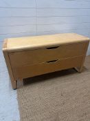 A contemporary light wood two drawer chest of drawers (H68cm W130cm D49cm)