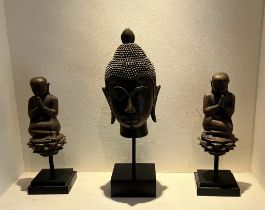 A Thai style Buddha head along with a kneeling Monks