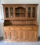 A pine three drawer and three cupboard dresser with two glazed cupboards and three drawers over (