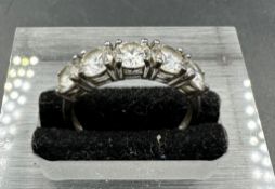 A silver ring marked 925 with five clear glass stones size O