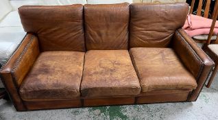 A three seater leather sofa with stud detail to base