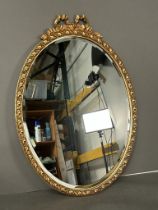 An oval wooden gold painted wall hanging mirror (50cm x 71cm)