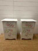 A pair white painted three drawer bedside tables with rose motif (H60cm W42cm D32cm)