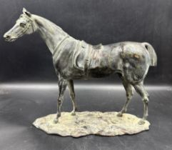 A bronze of a saddled horse, unsigned (Approximate measurements 24cm H and 29cm L)
