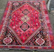 A hand knotted red ground carpet/rug with geometric pattern 204cm x 295cm