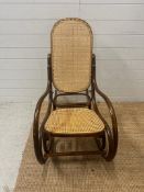 A Bentwood and cane seated rocking chair with scrolling arms