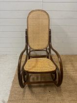 A Bentwood and cane seated rocking chair with scrolling arms