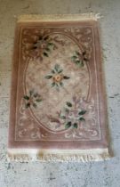 A brown rug with a floral motif (62cm x 104cm)