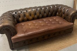 A brown leather Chesterfield style button back three seater sofa on bun feet (H72cm D91cm W186cm)