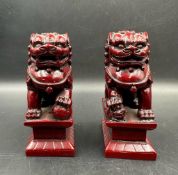 A pair of red resin Chinese foo dogs