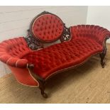 A Victorian carved and button backed salon sofa on scrolling feet and castors. (195cm L x 94cm H x