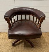 An late Victorian oak framed Captain chair upholstered in burgundy leather