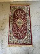 A red ground rug (110cm x 60cm)